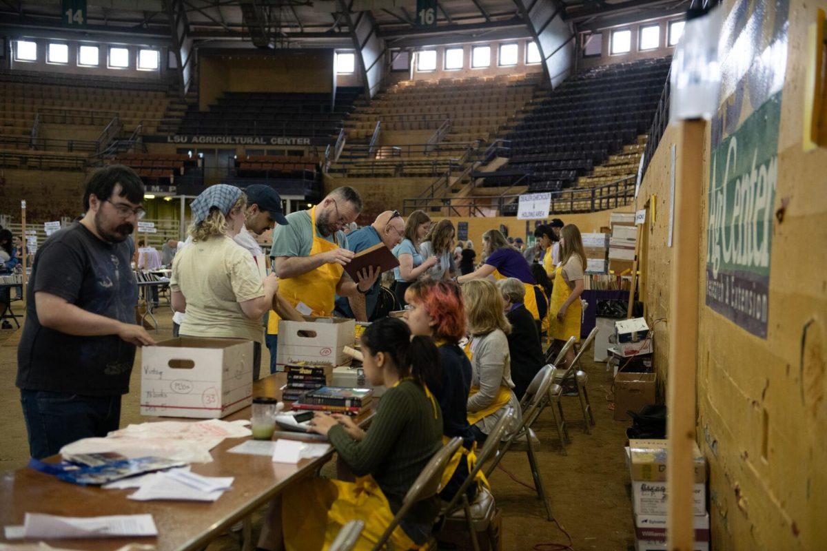 Volunteers check customers out Sunday, April 14, 2024, during the Friends of the LSU Libraries Book Bazaar at the John M. Parker Agricultural Coliseum in Baton Rouge, La.