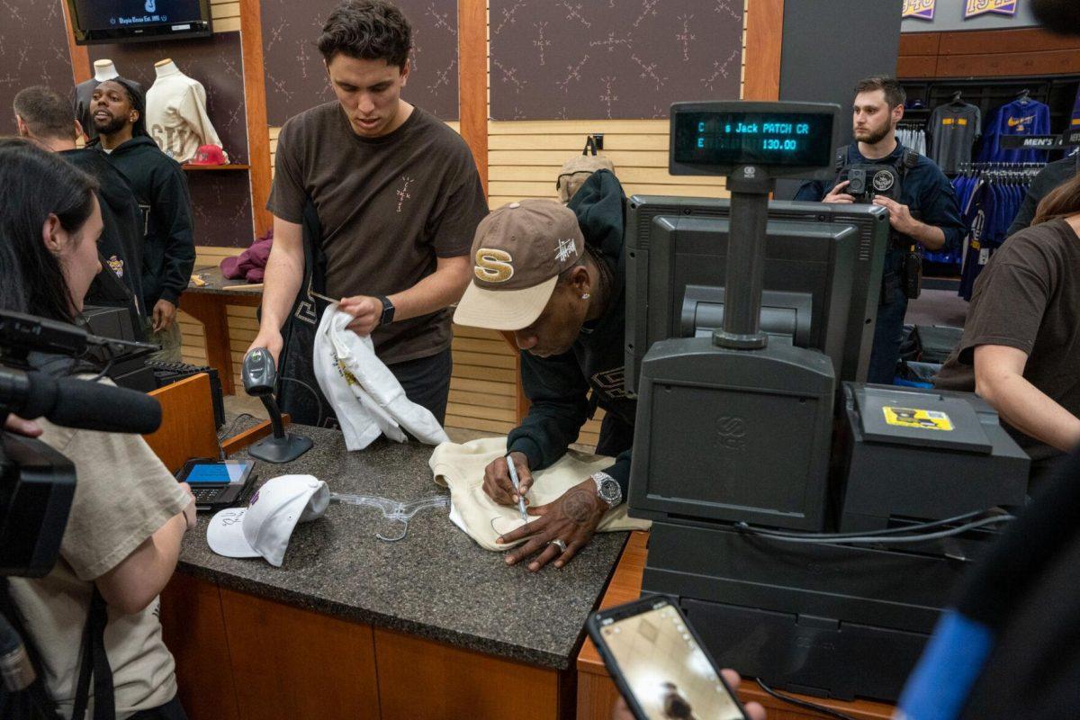 Travis Scott autographs a sweater Thursday, April 4, 2024, at the Barnes &amp; Nobles at LSU in Baton Rouge, La.