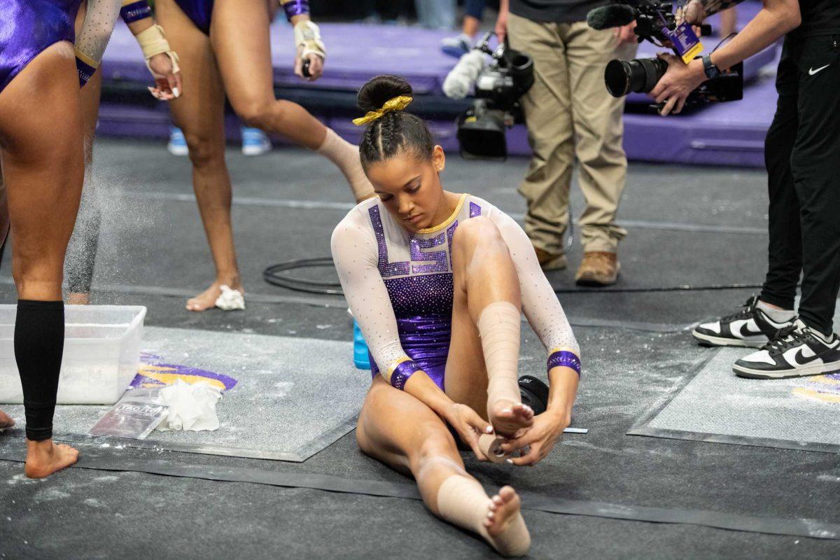 LSU gymnastics senior all-around Haleigh Bryant tapes her feet Friday, March 15, 2024, before LSU's 198.250-196.075 win against North Carolina at the Pete Maravich Assembly Center in Baton Rouge, La.