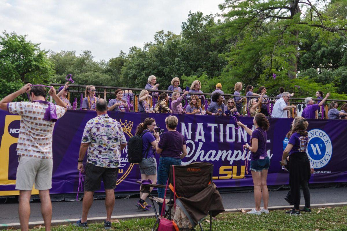 Parade participants throw beads Wednesday, April 24, 2024, at the LSU gymnastics championship parade on LSU's campus in Baton Rouge, La.