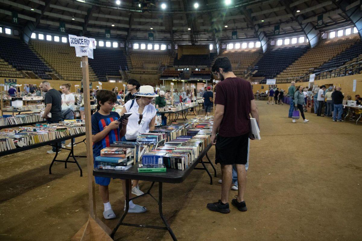 Readers peruse the science fiction section Sunday, April 14, 2024, during the Friends of the LSU Libraries Book Bazaar at the John M. Parker Agricultural Coliseum in Baton Rouge, La.