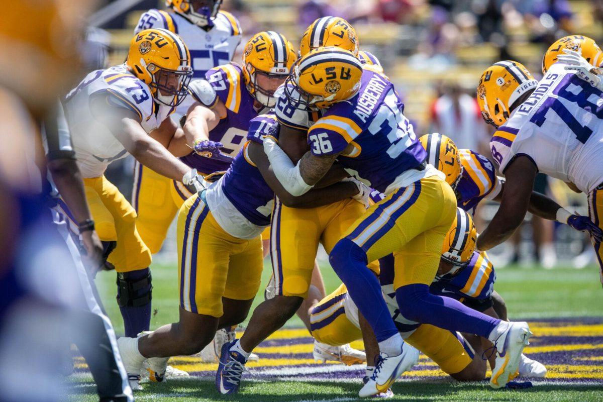 LSU football redshirt sophomore safety Austin Ausberry (36) holds back his 'opposing side' teammate to keep him from running the ball during the LSU Spring Football game on Saturday, April 13, 2024, in Tiger Stadium.