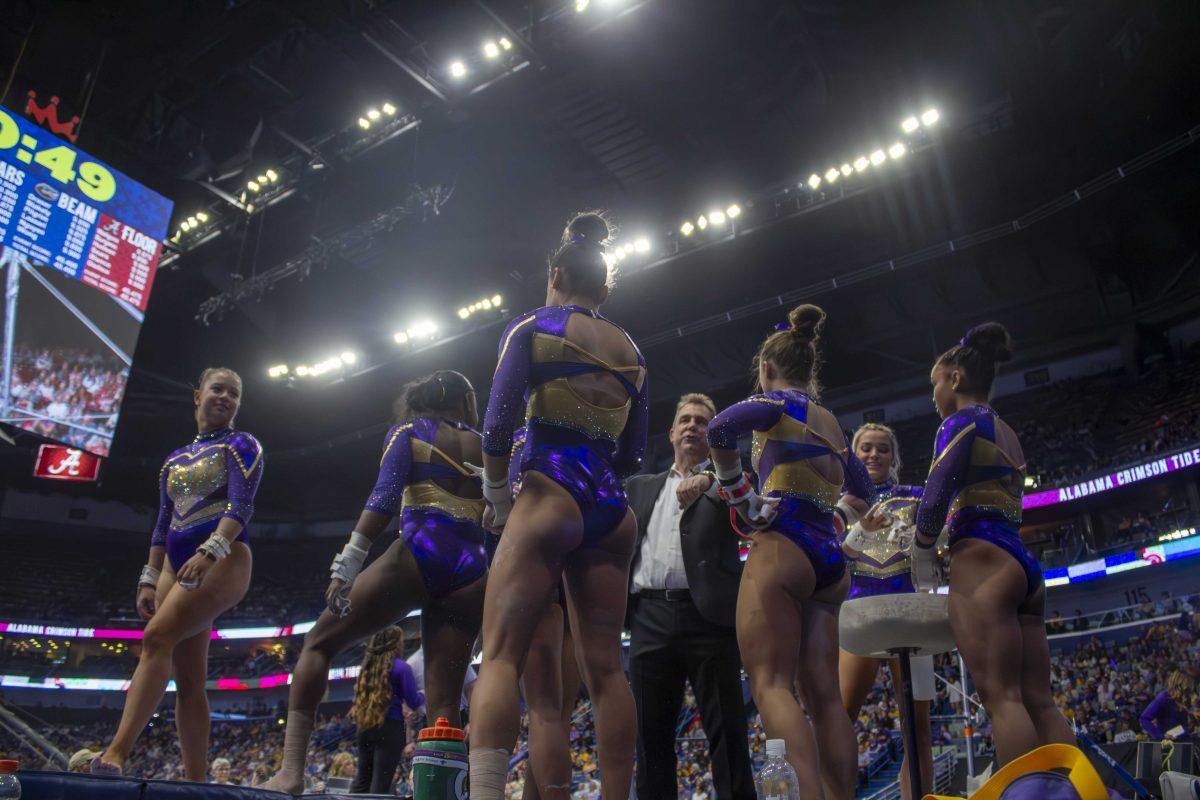 LSU gymnastics head coach Jay Clark speaks with his uneven bars team Saturday, March 23, 2024, during LSU's 198.075 victory in the 2024 SEC Gymnastics Championship in the Smoothie King Center in New Orleans, La.