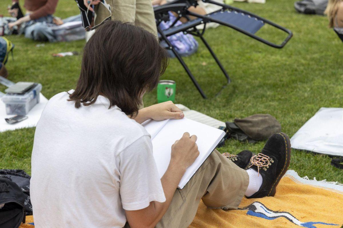 An art student sketches the parade grounds Monday, April 8, 2024, in anticipation of seeing the 2024 Solar Eclipse on the LSU Parade Ground.