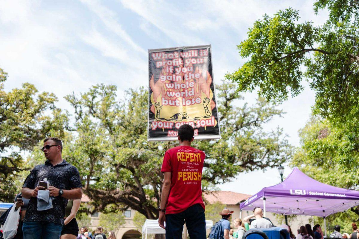 A man holds a repent sign in Free Speech Alley Tuesday, April 2, 2024, on LSU's campus in Baton Rouge, La.