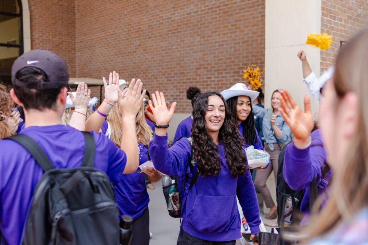 LSU gymnastics all-around senior Elena Arenas high fives fans Tuesday, April 16, 2024, as the team leaves for the NCAA semifinals in Forth Worth, Texas.