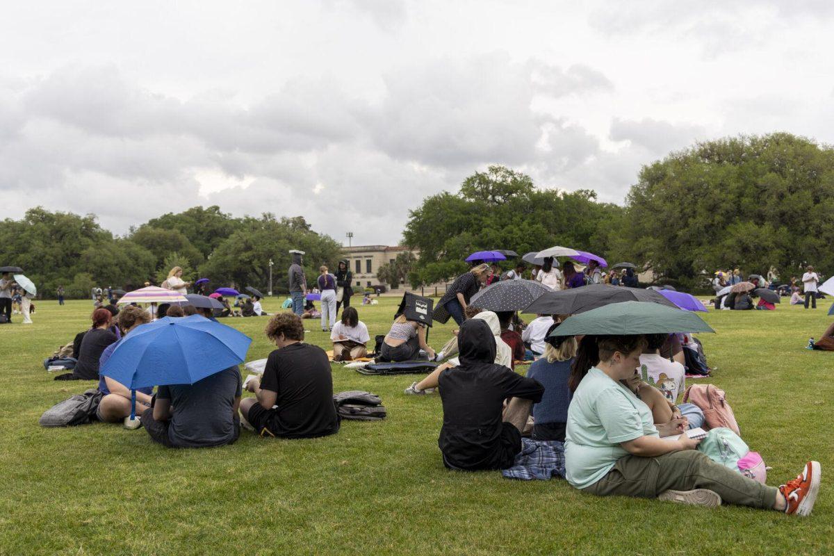 LSU eclipse watchers raise their umbrellas as the sky begins to rain Monday, April 8, 2024, in anticipation of seeing the 2024 Solar Eclipse on the LSU Parade Ground.