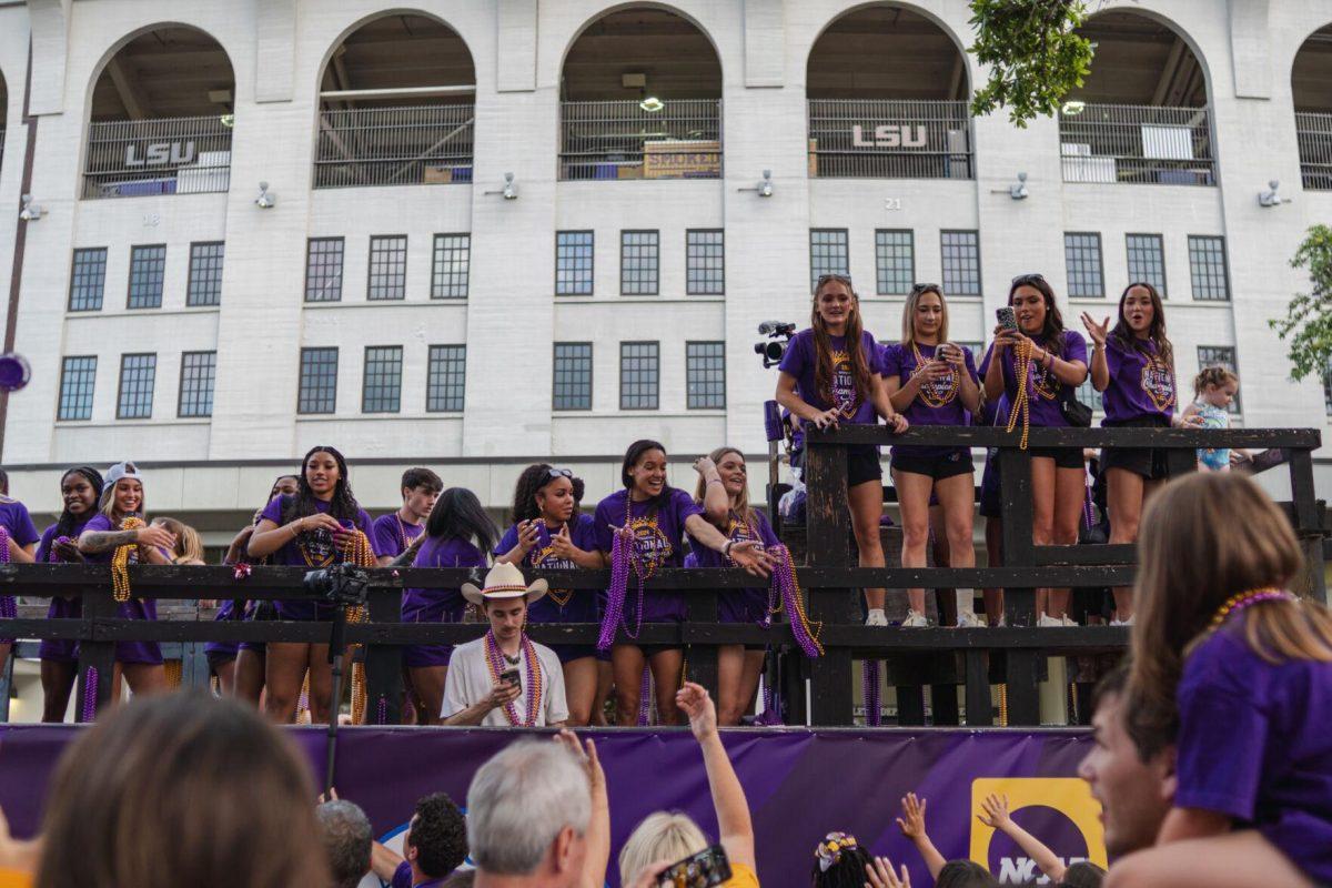 Members of the LSU gymnastics team throw beads from a float Wednesday, April 24, 2024, at the LSU gymnastics championship parade on LSU's campus in Baton Rouge, La.