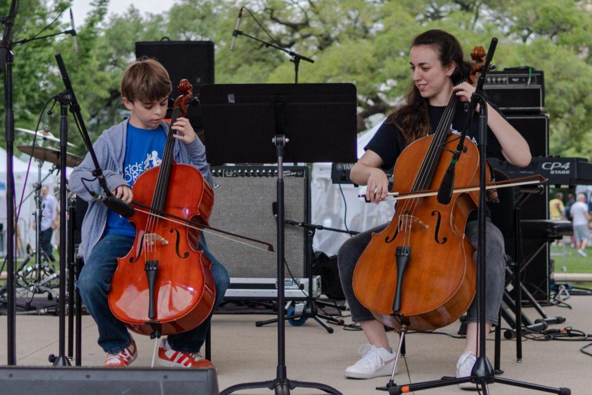 A member of the Kids' Orchestra performs with helper Saturday, April 20, 2024, at the Baton Rouge Blues Festival.