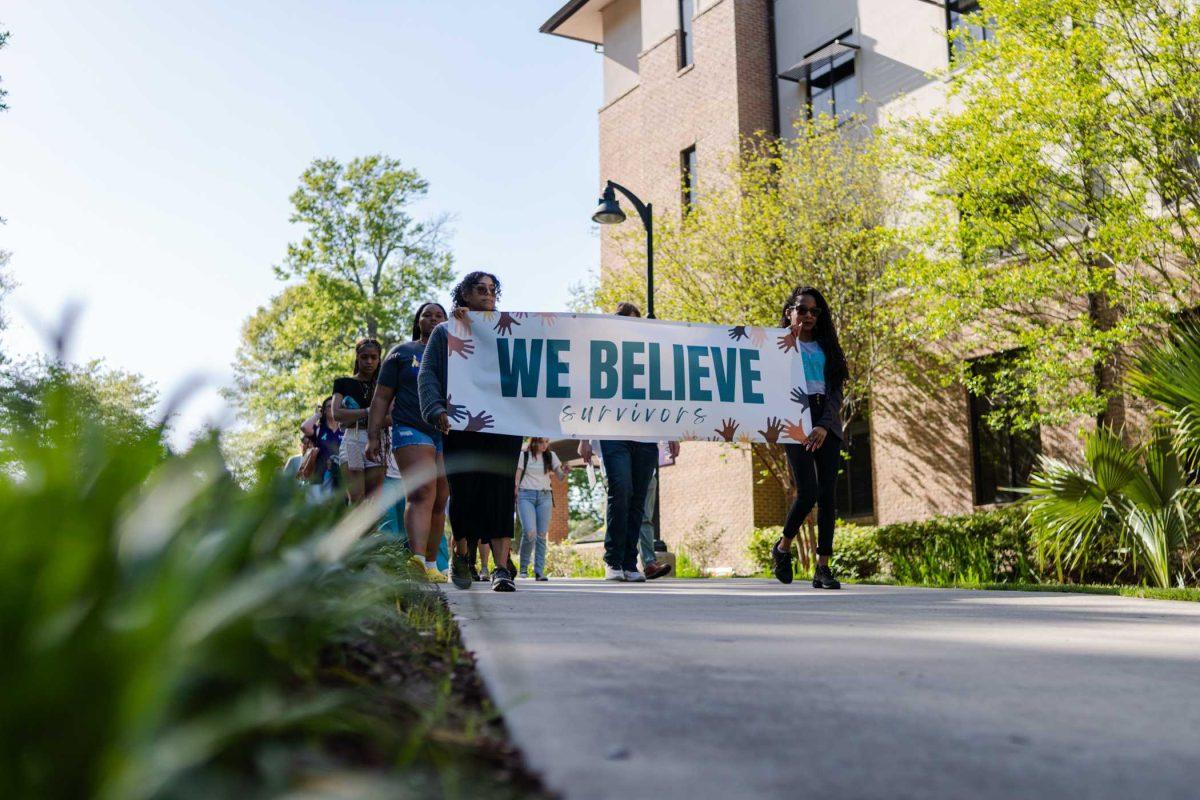 The march begins with a sign reading "We Believe Survivors" Tuesday, March 26, 2024, at the Believe March on LSU's campus.