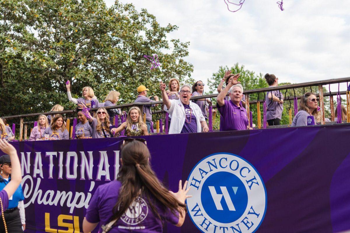 Parade participants throw beads Wednesday, April 24, 2024, at the LSU gymnastics championship parade on LSU's campus in Baton Rouge, La.