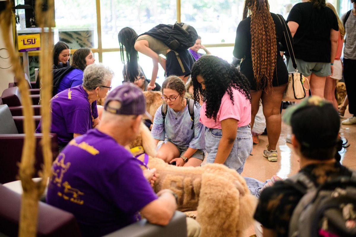 LSU students fill the area to pet dogs on Tuesday, April 30, 2024, in the LSU Library in Baton Rouge, La.