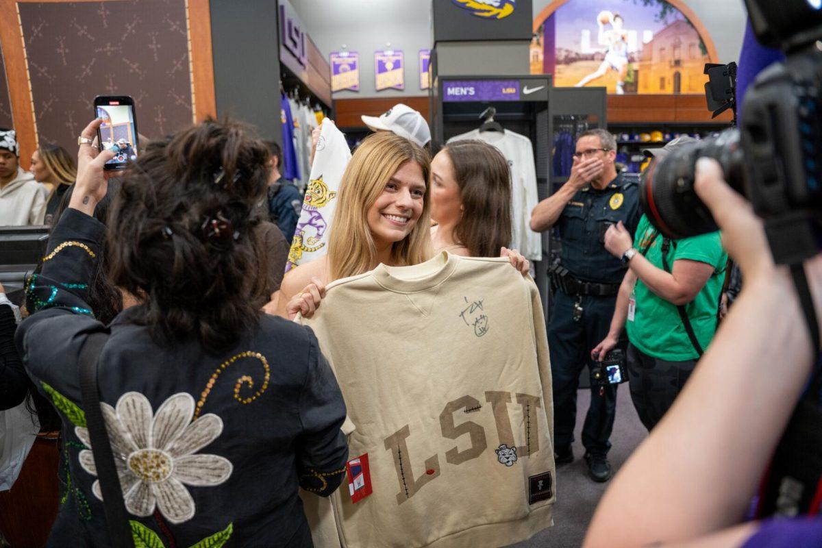 A student stands with her autographed sweater Thursday, April 4, 2024, at the Barnes &amp; Nobles at LSU in Baton Rouge, La.