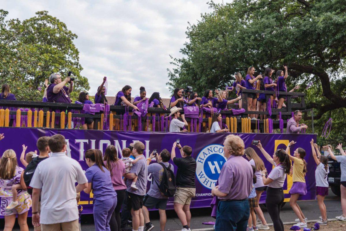 Members of the LSU gymnastics team throw beads from a float Wednesday, April 24, 2024, at the LSU gymnastics championship parade on LSU's campus in Baton Rouge, La.