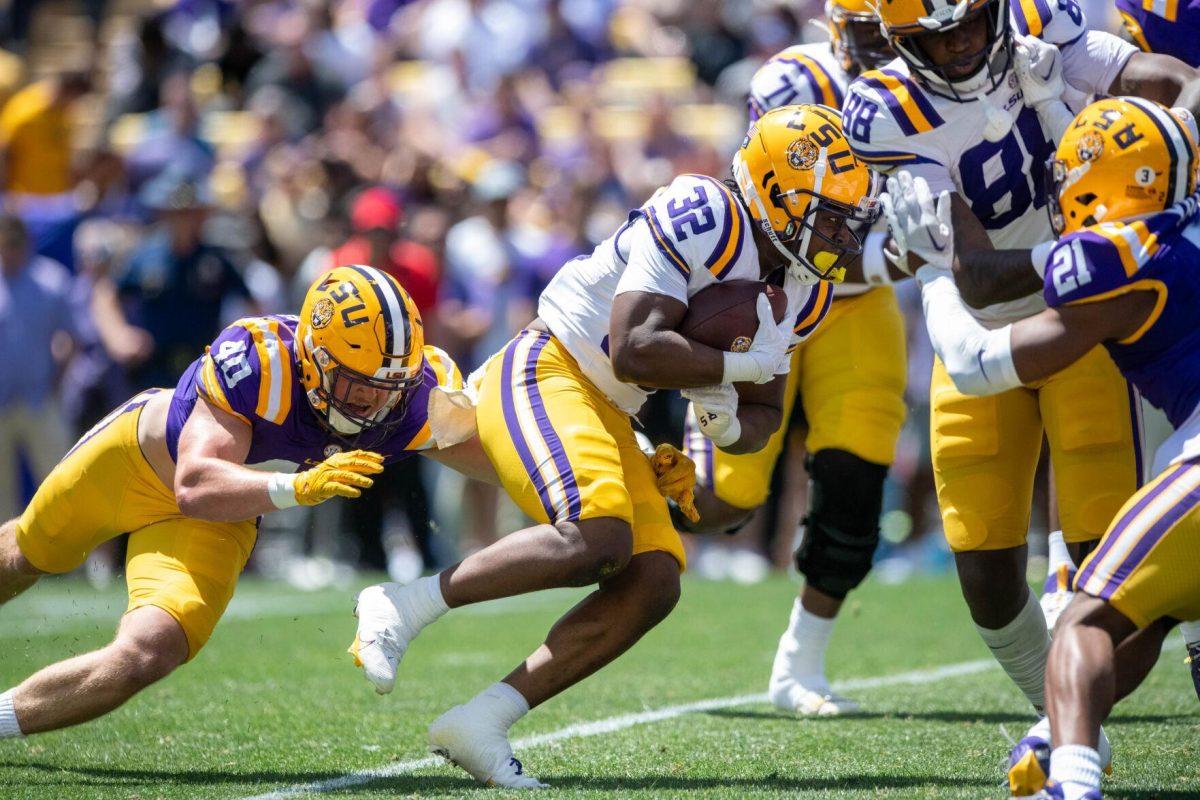 LSU football sophomore linebacker Whit Weeks (40) jumps for football redshirt freshman running back Joseph Ebun (32) while running the ball during the LSU Spring Football game on Saturday, April 13, 2024, in Tiger Stadium.