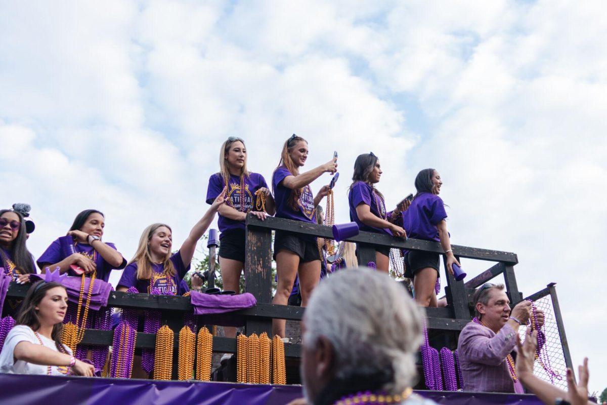 Members of the LSU gymnastics team throw beads from a float Wednesday, April 24, 2024, at the LSU gymnastics championship parade on LSU's campus in Baton Rouge, La.