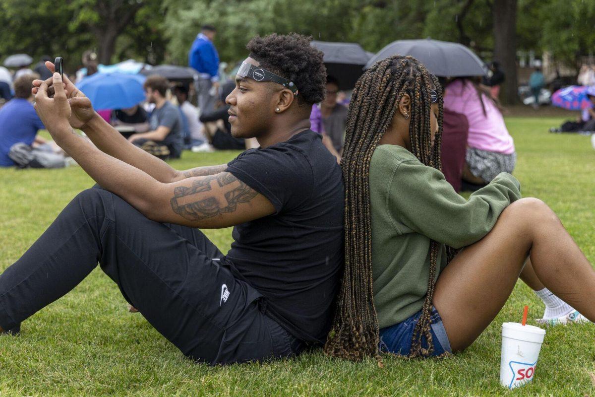 LSU architecture freshman Vontae Rowe (left) and public relations freshman Azariah Harrison (right) wait for the sky to clear Monday, April 8, 2024, in anticipation of seeing the 2024 Solar Eclipse on the LSU Parade Ground.