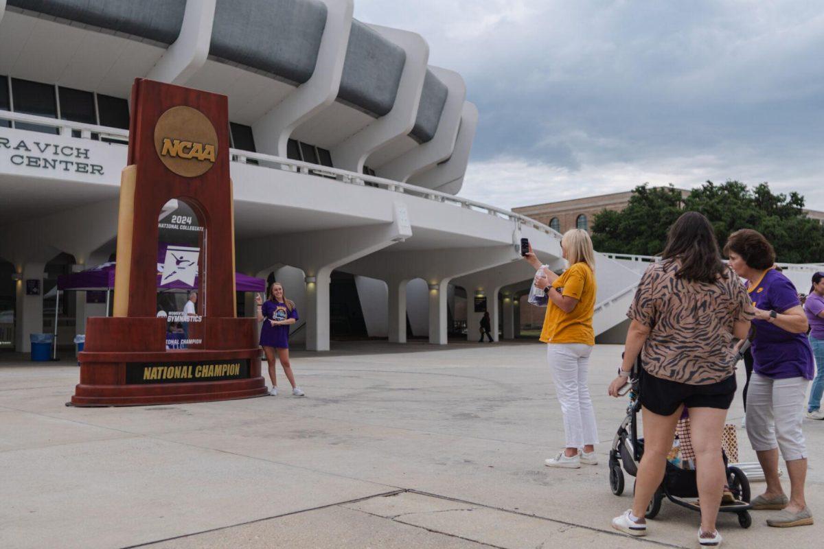 People wait in line to take a picture with the giant trophy Wednesday, April 24, 2024, at the LSU gymnastics championship parade on LSU's campus in Baton Rouge, La.