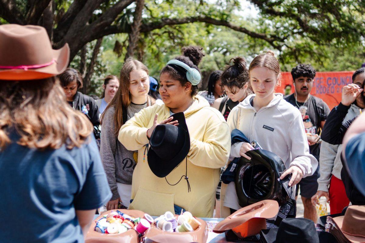 Students wait to grab a cowboy hat Tuesday, April 2, 2024, at the College Council Rodeo on Tower Drive on LSU's campus.