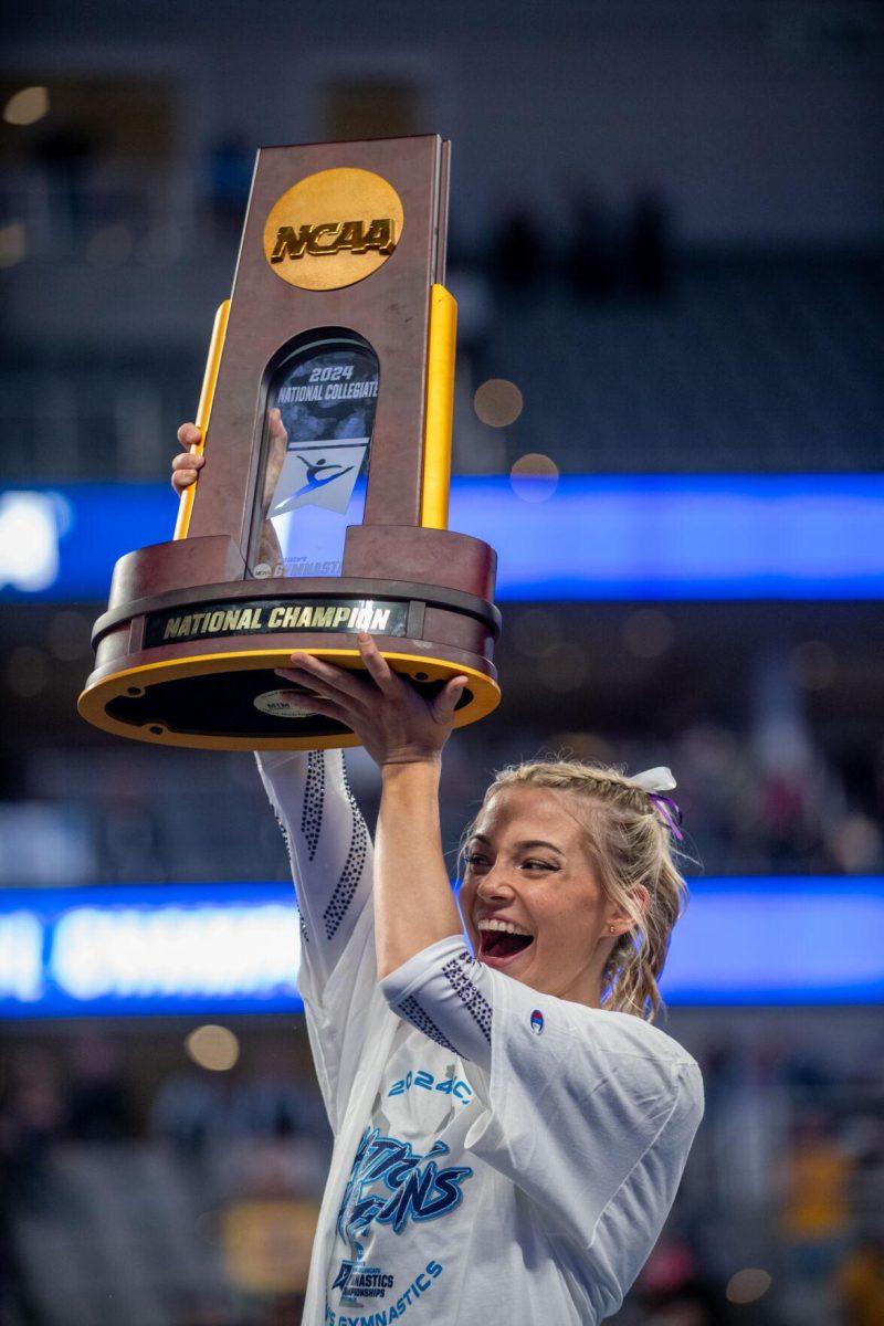 LSU gymnastics all-around Olivia Dunne holds up the trophy and cheers following LSU's NCAA Championship win on Saturday, April 20, 2024, in Fort Worth, Tx.