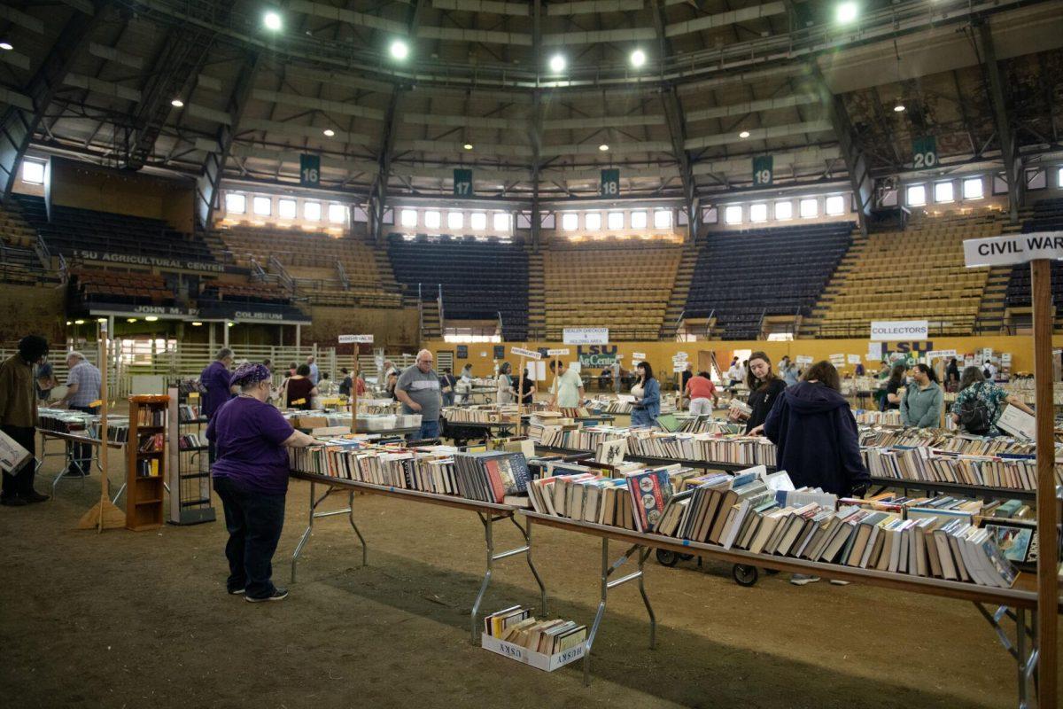 Readers look through tables of books Sunday, April 14, 2024, during the Friends of the LSU Libraries Book Bazaar at the John M. Parker Agricultural Coliseum in Baton Rouge, La.