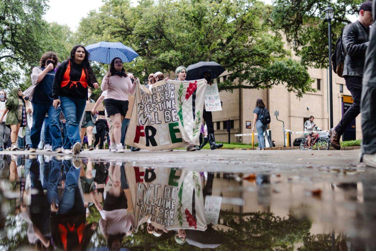 Pro-Palestinian protesters march Friday, May 3, 2024, down Tower Drive on LSU's campus in Baton Rouge, La.