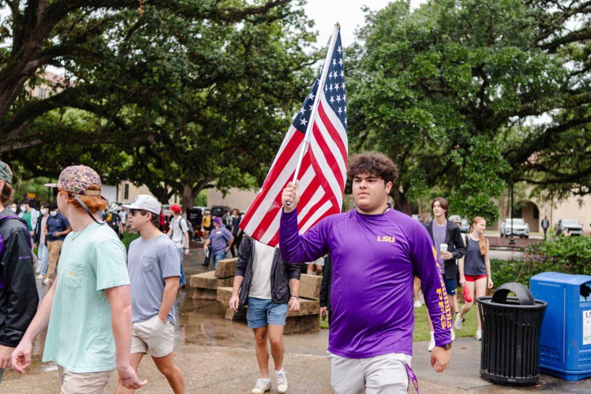 A counter-protester walks with an American flag Friday, May 3, 2024, in Free Speech Alley on LSU's campus in Baton Rouge, La.