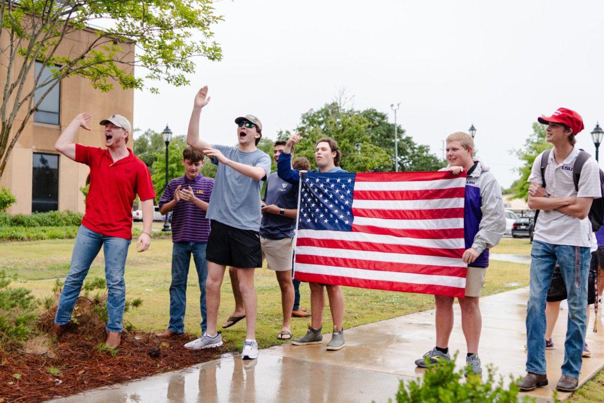 Counter-protesters hold up an American flag while chanting Friday, May 3, 2024, outside of Patrick F. Taylor Hall on LSU's campus in Baton Rouge, La.