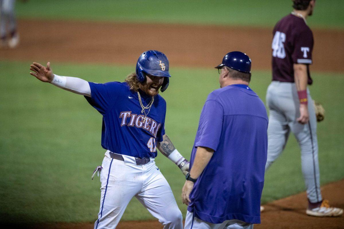 LSU baseball junior third basemen Tommy White (47) high fives assistant coach Marc Wanaka after his base hit during LSU's 6-4 win on Saturday, May 4, 2024, at Alex Box Stadium in Baton Rouge, La.