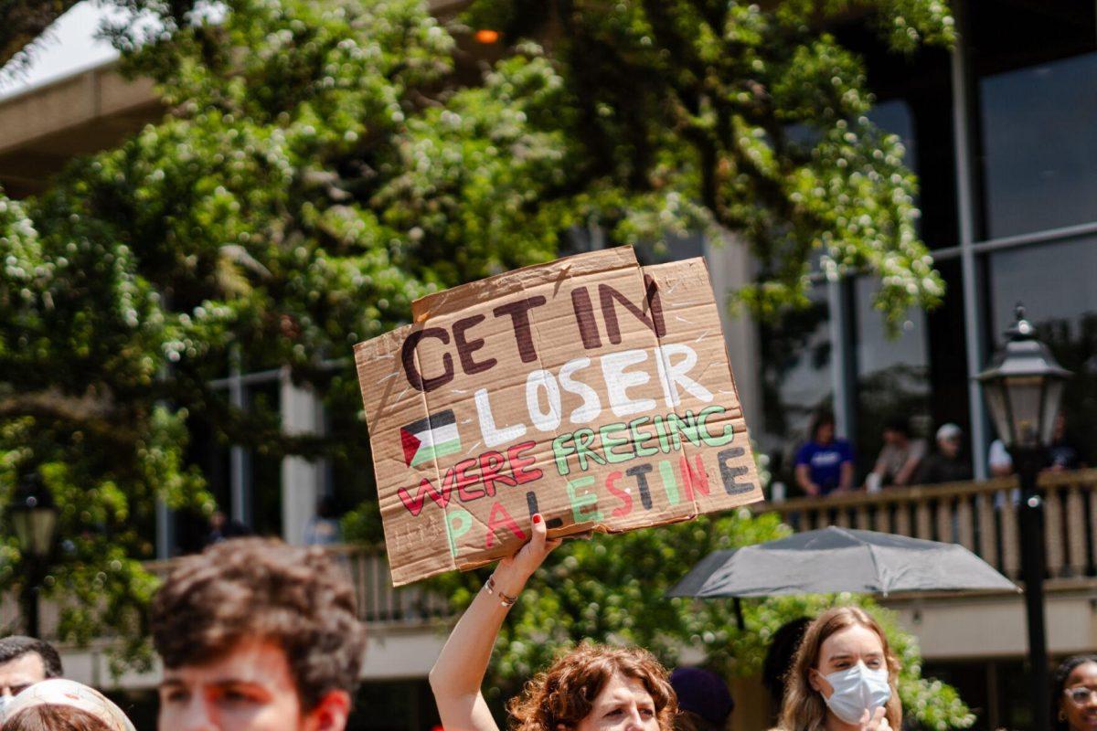 A pro-Palestinian protester holds a sign reading "Get in loser were freeing Palestine" Friday, May 3, 2024, in Free Speech Alley on LSU's campus in Baton Rouge, La.