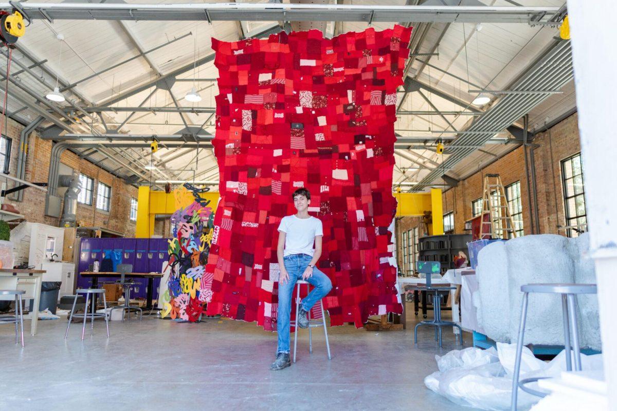 LSU 5th-year sculpture major Adrianna Hawkins sits in front of the quilt Wednesday, May 1, 2024, inside the Barnes Ogden Art &amp; Design Complex on LSU's campus in Baton Rouge, La.