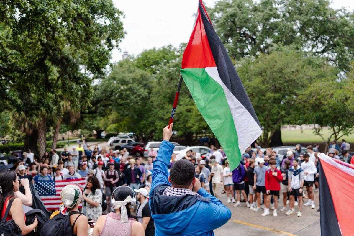 A pro-Palestinian protester waves a Palestinian flag Friday, May 3, 2024, in Free Speech Alley on LSU's campus in Baton Rouge, La.