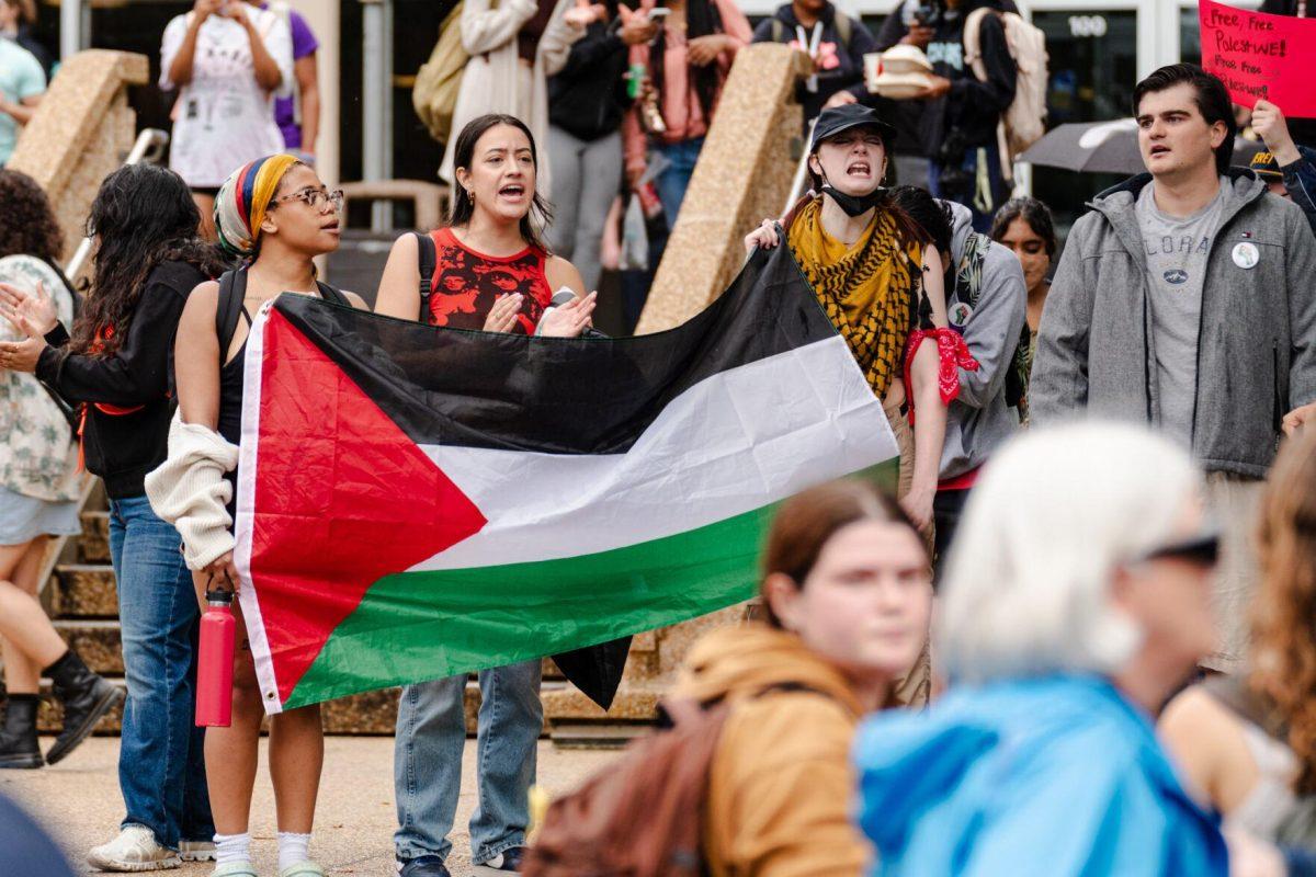 Pro-Palestinian protesters chant and hold a Palestinian flag Friday, May 3, 2024, on the Student Union steps on LSU's campus in Baton Rouge, La.