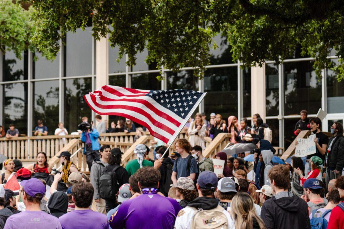 An American flag flies amongst the crowd Friday, May 3, 2024, in Free Speech Alley on LSU's campus in Baton Rouge, La.