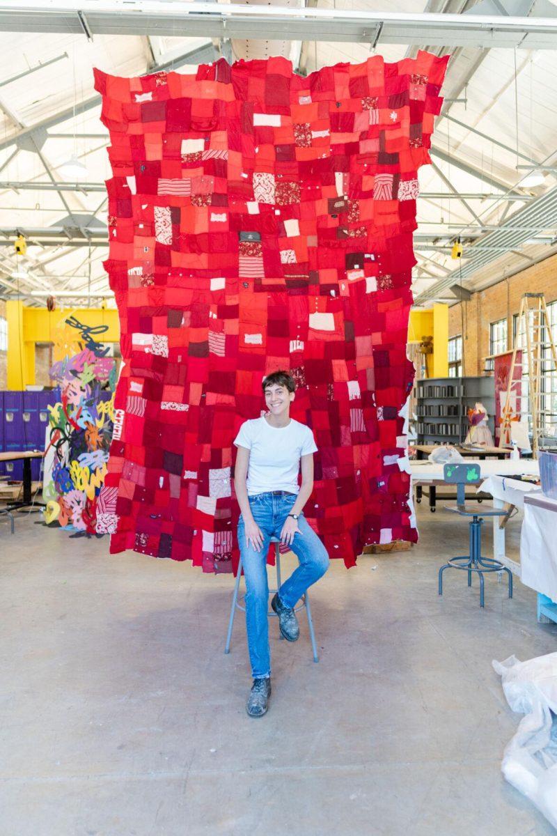 LSU 5th-year sculpture major Adrianna Hawkins sits in front of the quilt Wednesday, May 1, 2024, inside the Barnes Ogden Art &amp; Design Complex on LSU's campus in Baton Rouge, La.