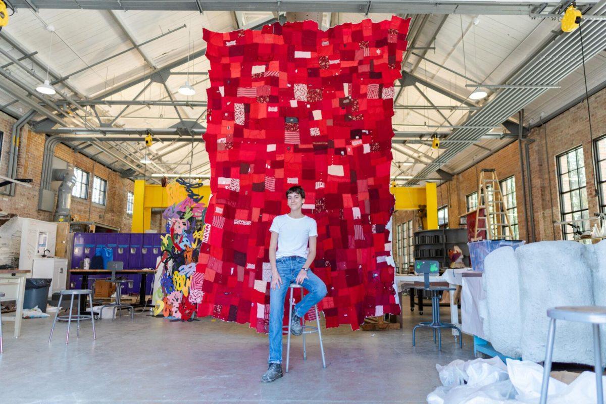 LSU 5th-year sculpture major Adrianna Hawkins sits in front of the quilt Wednesday, May 1, 2024, inside the Barnes Ogden Art &amp; Design Complex on LSU's campus in Baton Rouge, La.