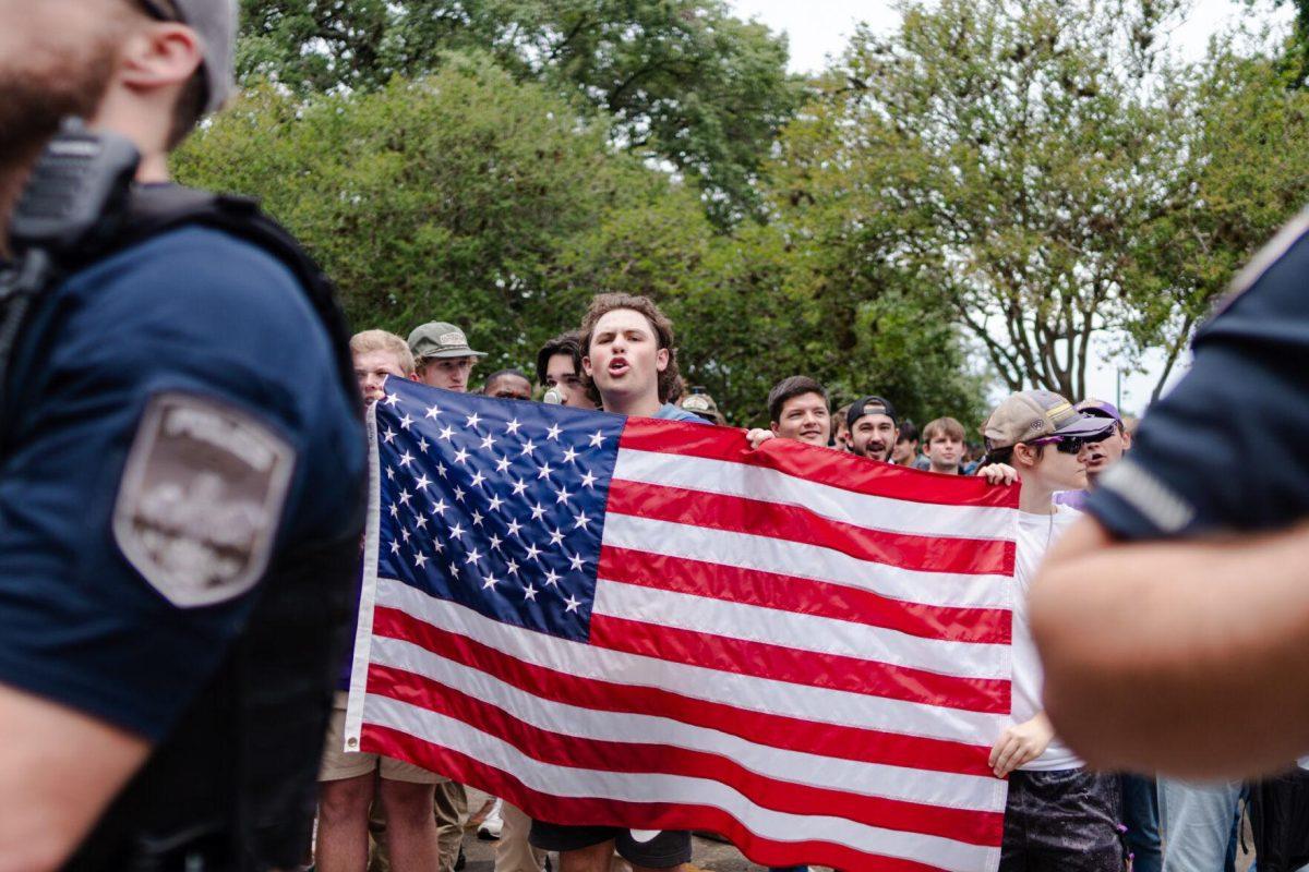 Counter-protester Ethan Vogin holds an American flag Friday, May 3, 2024, in Free Speech Alley on LSU's campus in Baton Rouge, La.