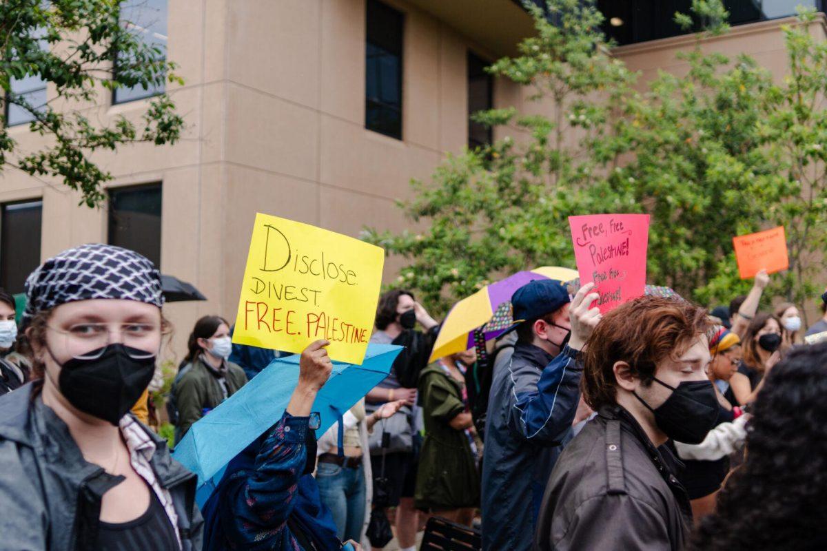 A pro-Palestinian protester holds a sign reading "Disclose. Divest. Free. Palestine." Friday, May 3, 2024, outside of Patrick F. Taylor Hall on LSU's campus in Baton Rouge, La.