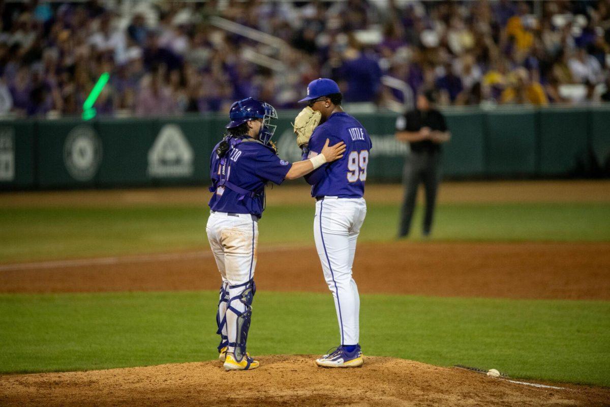 LSU baseball graduate student catcher Alex Milazzo (7) speaks to teammate Christian Little (99) on the mound during LSU's 6-4 win on Saturday, May 4, 2024, at Alex Box Stadium in Baton Rouge, La.