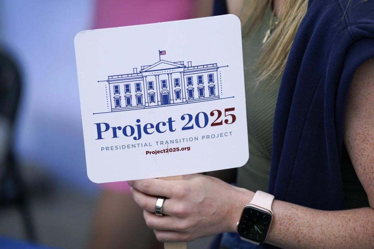 Kristen Eichamer holds a project 2025 fan in the group's tent at the Iowa State Fair, Aug. 14, 2023, in Des Moines, Iowa.