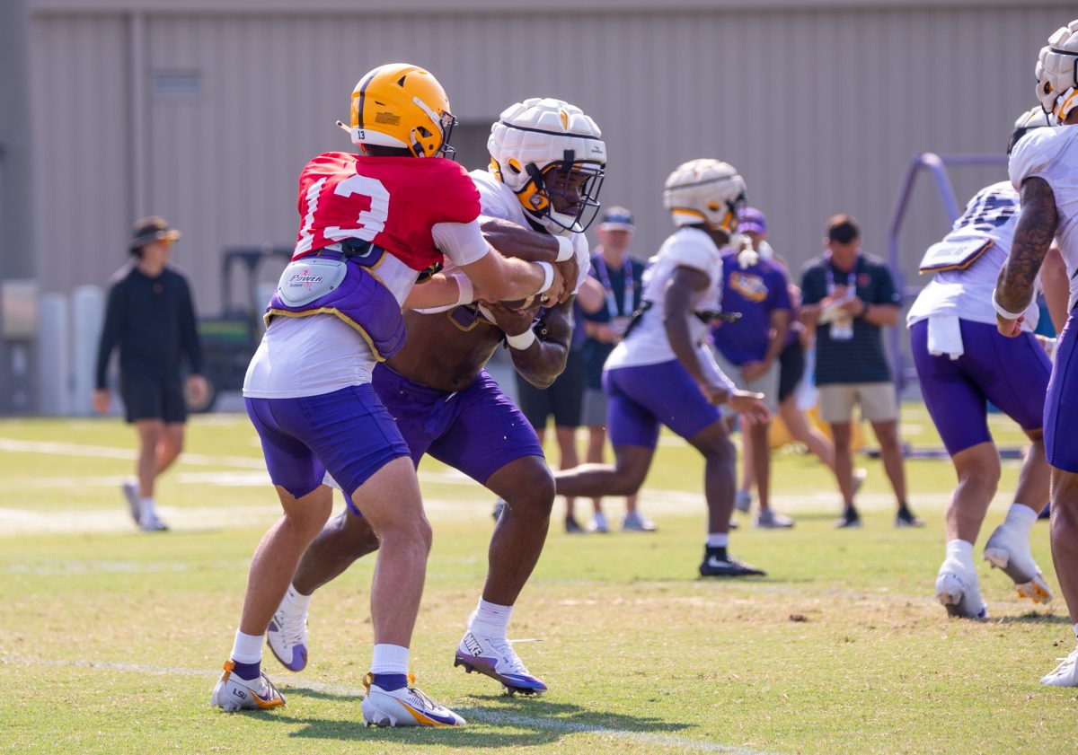 <p>LSU football redshirt junior quarterback Garrett Nussmeier (13) hands the ball to sophomore running back Kaleb Jackson (28) during the LSU Fall Camp practice on Tuesday, Aug. 13, 2024, in Baton Rouge.</p>