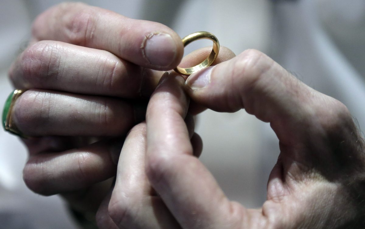 In this Wednesday, Nov. 5, 2014 photo, Numis International Inc. owner Jacob Notowitz examines a gold ring at his store in Millbrae, Calif. All of the reasons for buying gold over recent years have disappeared, helping to drive prices for the metal to a four-year low.