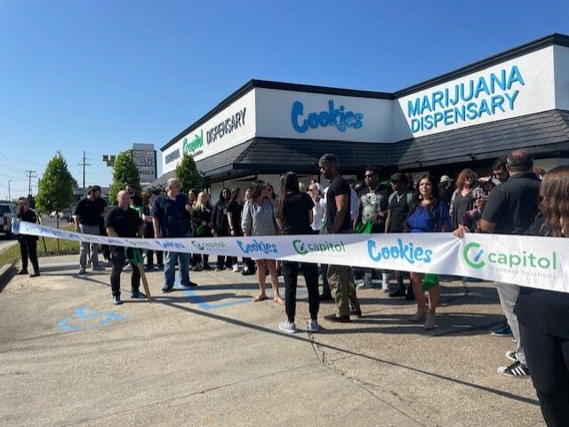 Attendees gather at the front of the store for the official ribbon cutting.