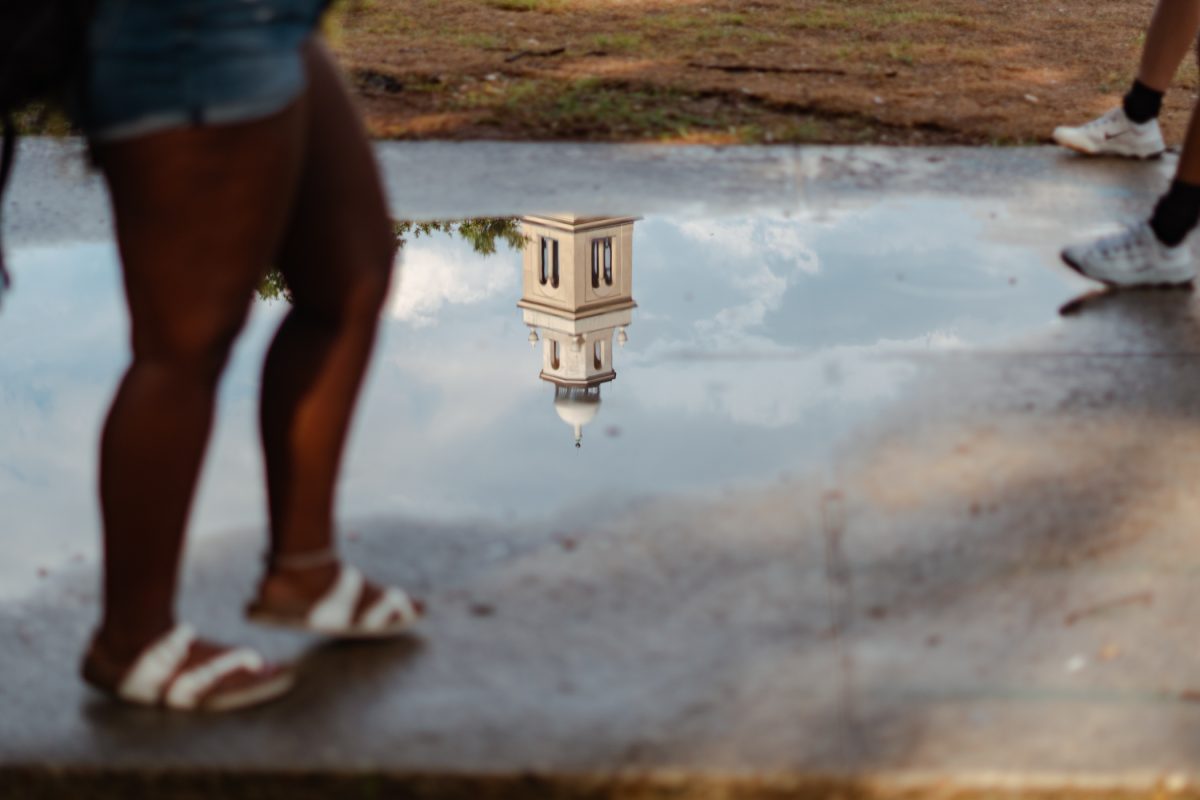 Memorial Tower reflects in a puddle on Tuesday, Sept. 26, 2023, in the LSU Quad.