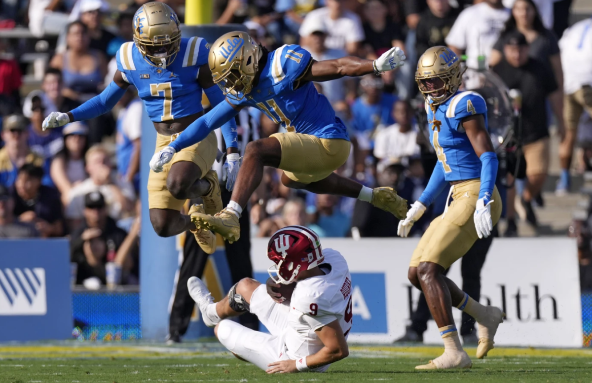 Indiana quarterback Kurtis Rourke, below, slides as UCLA defensive back K.J. Wallace, left, defensive back Ramon Henderson, center, and defensive back Bryan Addison defend during the first half of an NCAA college football game, Saturday, Sept. 14, 2024, in Pasadena, Calif.