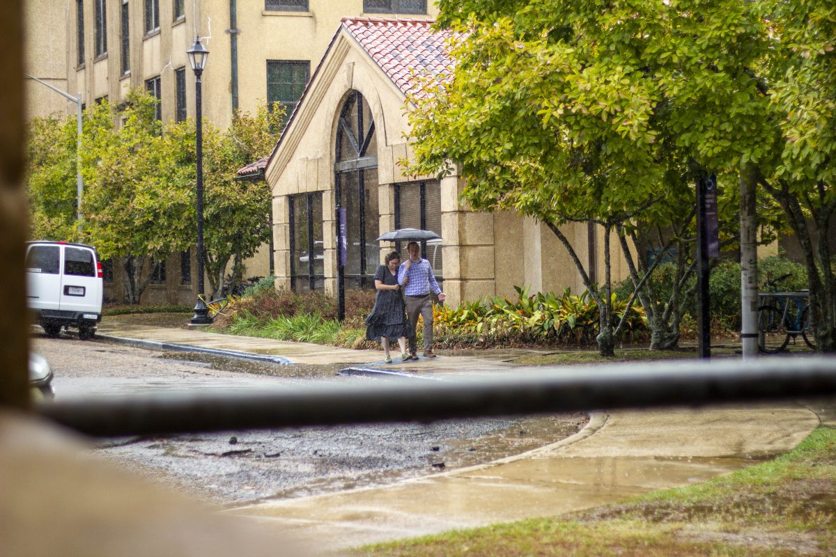 Visitors walk through the rain under an umbrella Tuesday, Sept. 26, 2023, on LSU's campus in Baton Rouge, La.