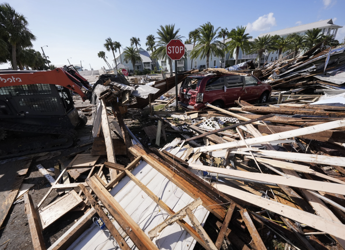 Workers clear debris in the aftermath of Hurricane Helene, in Cedar Key, Fla., Friday Sept. 27, 2024.