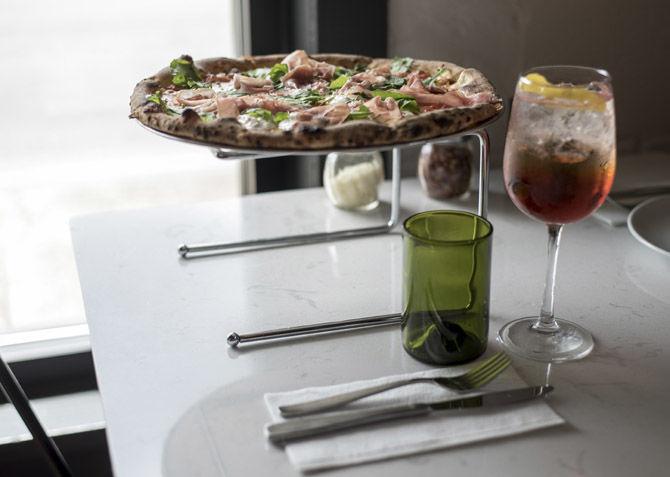 <p>A prosciutto pizza sits with an aperol spritz at Rocca Pizzeria on Tuesday, Feb. 27, 2018.</p>