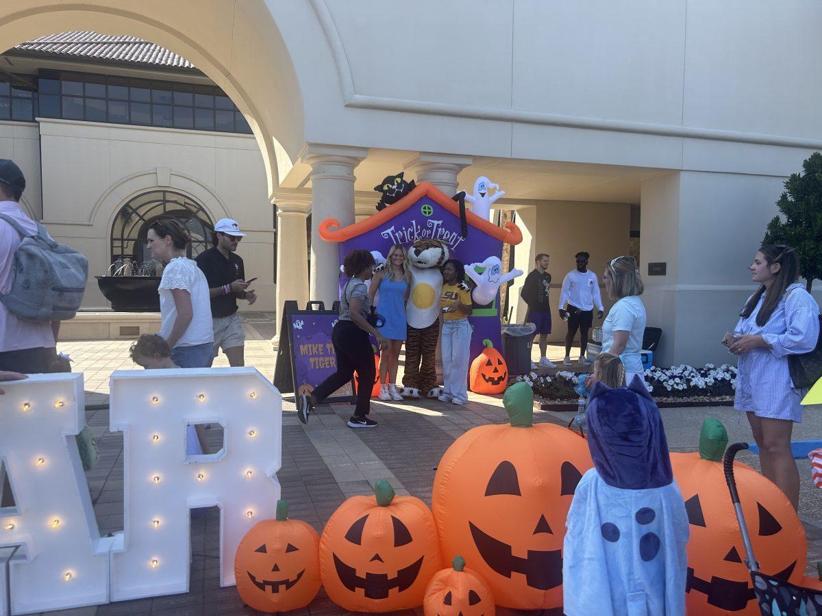 Trick or Treat Down the Row attendees taking photos in front of the Lod Cook Alumni Center on W. Lakeshore Drive.