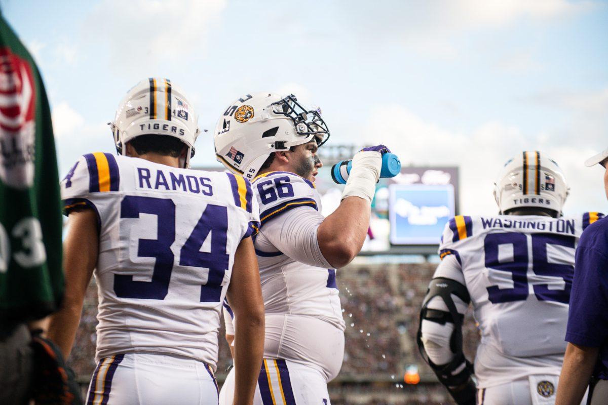LSU football redshirt junior placekicker Damian Ramos (34), junior offensive tackle Will Campbell (66), and redshirt sophomore defensive tackle Shone Washington take a break from warmups on Saturday, Oct. 26, 2024, during LSU's 23-38 loss against Texas A&amp;M at Kyle Field in College Station, Texas. 